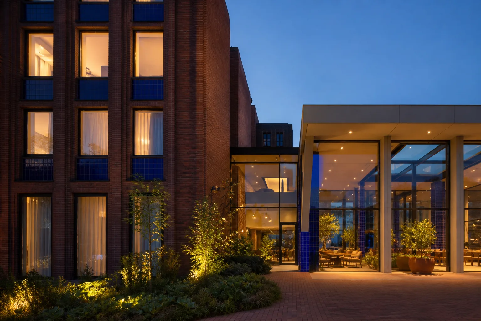 Modernistisch hotel van baksteen en blauw tegelwerk bij het vallen van de avond